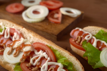 sandwich with sausage and vegetables on a wooden table