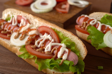 sandwich with sausage and vegetables on a wooden table