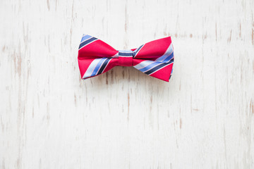 Men's accessories with plaid bow tie on rustic wooden background 
