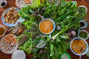Peculiar herbs salad in Kon Tum, Vietnam. Using the leaves to make a cone-shaped container to put...