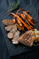 Roasted duck breast fillet with baked carrot and honey, close-up