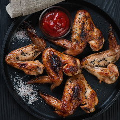 Cast-iron pan with bbq chicken wings, close-up, flat-lay view