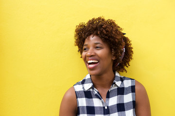 african woman laughing against yellow background