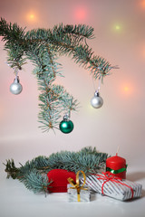 Branch of Christmas tree with balls, Christmas box and candle