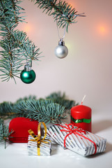 Branch of Christmas tree with balls, Christmas box and candle