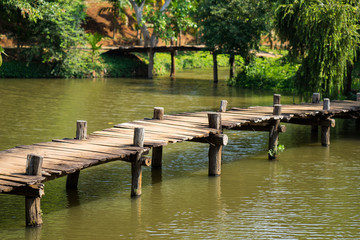 Old walking wooden bridge on lake