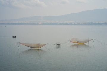 Big fish net on lake at morning fog