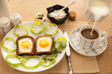 Healthy breakfast with toasted bread and eggs with cup of tea and milk.