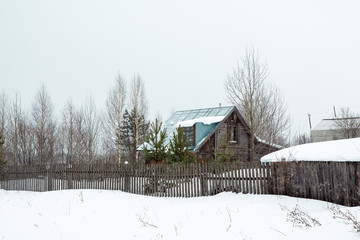 Fototapeta na wymiar Village in a winter and snowfall