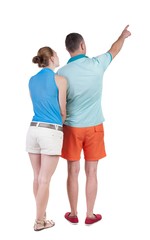 young couple in short pointing at wal