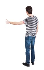 Back view of  man in shirt shows thumbs up.