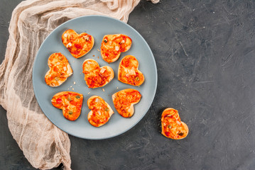 Romantic foods for Valentine's Day. Miniature pizza at one bite, cheese and fresh vegetables, close view, copy space, top view