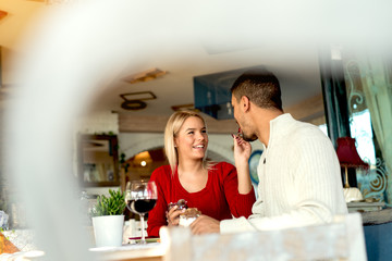 Multiracial couple enjoying at restaurant.