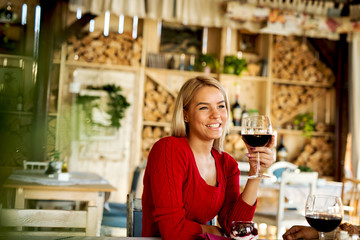 Beautiful young lady drinking wine at restaurant.