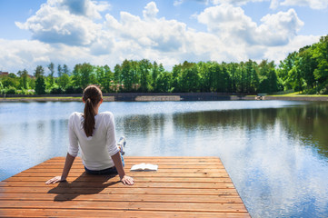 Fototapeta Woman relaxing by a beautiful lake.  obraz