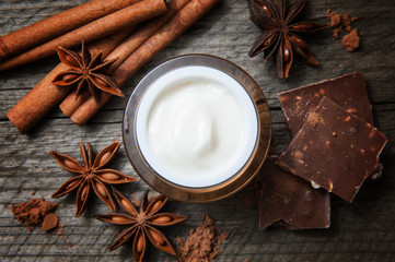 Chocolate skin treatment. Cosmetic jar with lotion, cocoa, anise, cinnamon sticks.
