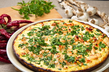Quiche with chicken, onions, sprinkled  parsley.