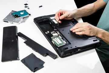 Repairing old laptop PC. Person repairs old PC, disassembles its parts and does maintenance