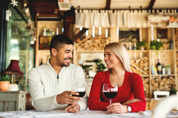 Lovely multiracial couple drinking wine at restaurant.