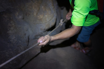 Fototapeta na wymiar Hands holding rope. Concept of dangerous trekking in Son Doong Cave, the largest cave in the world in UNESCO World Heritage Site Phong Nha-Ke Bang National Park, Quang Binh province, Vietnam