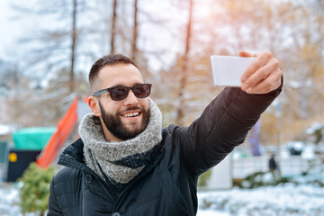 Fototapeta premium Young Man Smile Camera Taking Selfie Photo In Winter Snow Forest Guy Outdoors Walking White Park