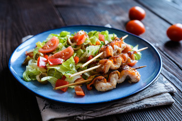 Chicken skewers with zucchini slices and vegetable salad