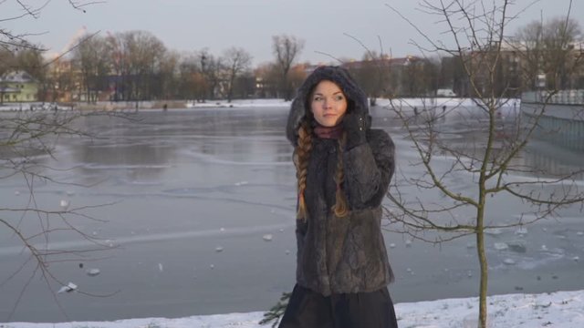 Young beautiful woman posing over winter forest. Outdoor winter portrait over snowy background. slow motion from 50 fps Full HD