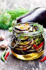 Grilled  sliced eggplant with chili in glass jar on rustic table
