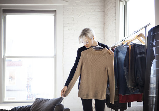 Young Woman Selecting Clothes At Home