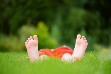 Naklejka premium Childrens feet on grass outdoors