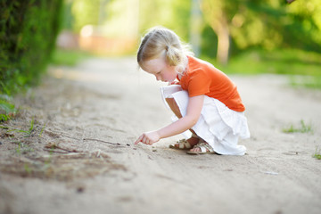 Adorable little girl catching little babyfrogs