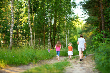 Obraz premium Two vute little sisters hiking in a forest with their grandmother