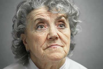Grandmother thoughtful face on a grey