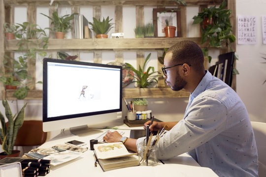 Male Illustrator Making Painting On Computer In Creative Office