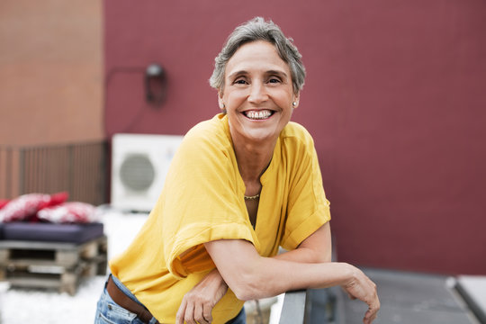 Portrait of happy mature woman standing on terrace
