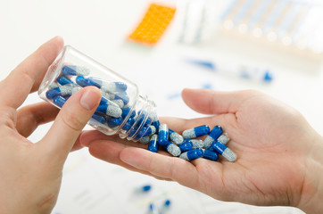 Person pouring out pills on hand