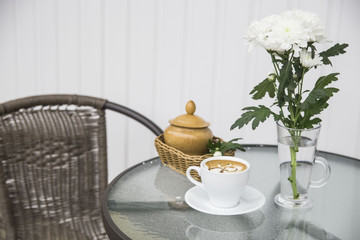 morning coffee next to a vase of chrysanthemums on the summer terrace cafe