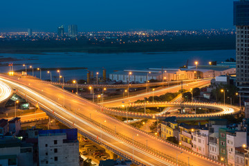 Fototapeta na wymiar Hanoi cityscape. Aerial view of enter way to Vinh Tuy bridge at twilight