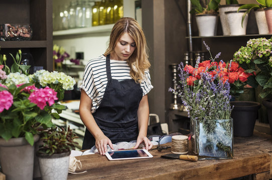 Woman using digital tablet in flower shop