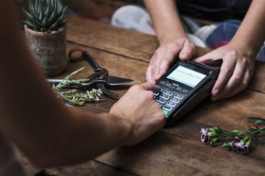 Cropped image of customer paying with credit card in flower shop