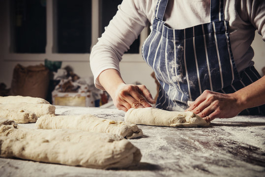 Midsection of woman kneading dough at table