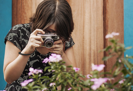 Woman taking picture of flowers with camera