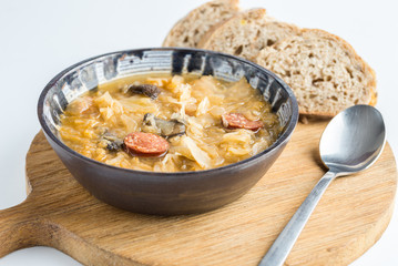 Christmas cabbage soup with mushrooms on natural cutting desk.