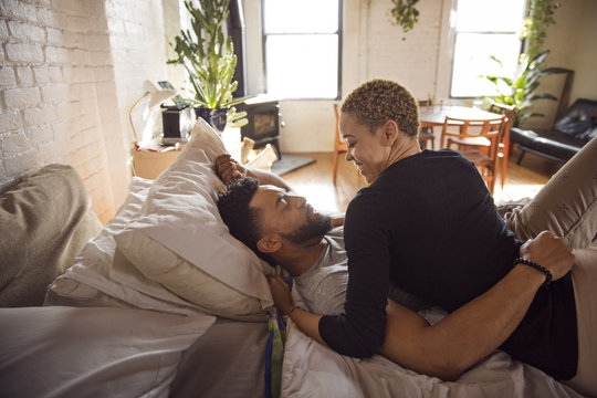 Couple relaxing while lying on bed at home