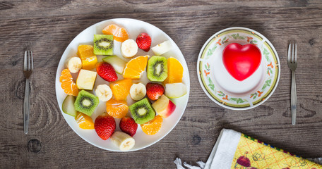 Fototapeta na wymiar plate of fruit and heart on the table / concept of health
