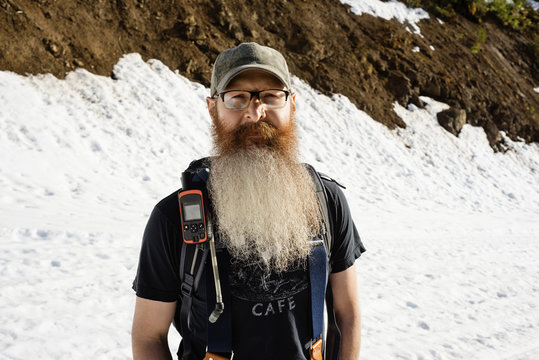 Portrait of confident man standing on snow covered mountain