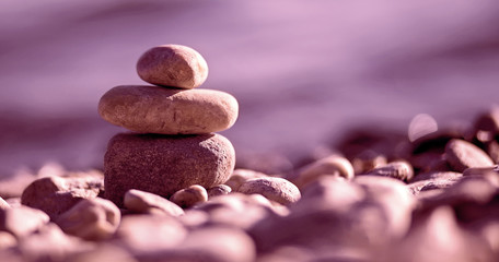 Website banner of Zen balancing pebbles on the beach in purple