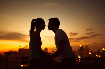 Fototapeta na wymiar Young couple kissing at twilight. 