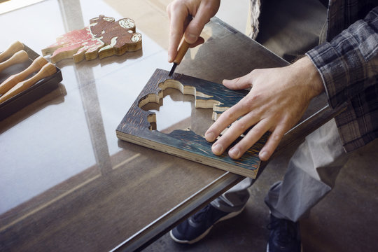 Cropped image of worker carving wood at workshop