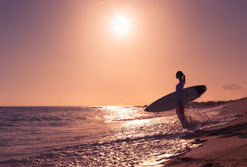 Female surfer on the beach. - Powered by Adobe